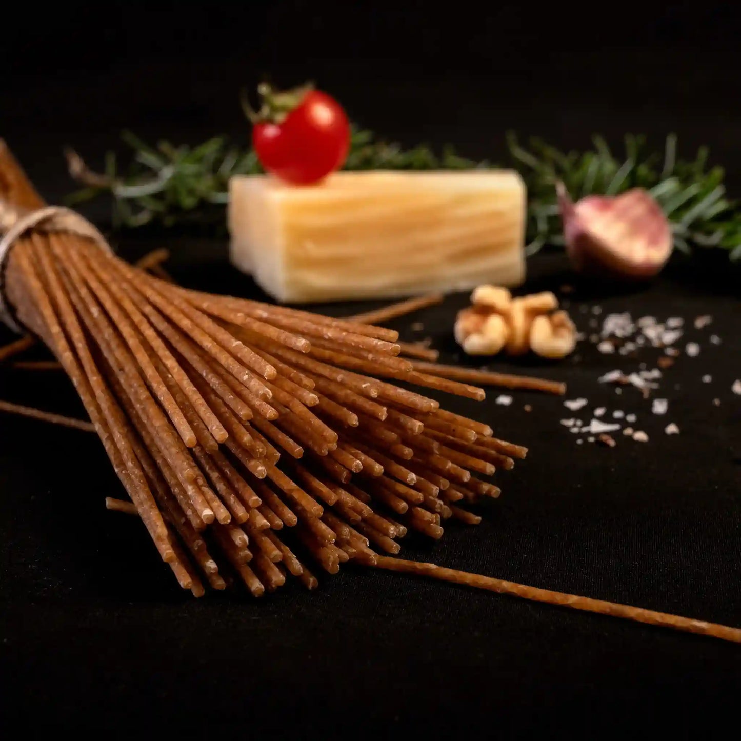 Multiple pieces of uncooked Organic Einkorn Spaghetti with assorted food items